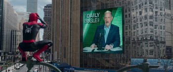 Movie still from “Spider-Man: No Way Home” (2021), directed by Jon Watts – A large television screen in front of a building; Extreme Wide shot, Over the shoulder angle