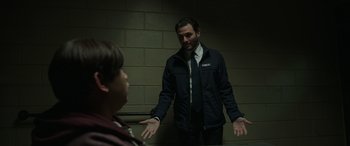 Movie still from “Spider-Man: No Way Home” (2021), directed by Jon Watts – A man standing next to a young boy in a room; Medium shot, Over the shoulder angle