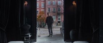 Movie still from “Spider-Man: No Way Home” (2021), directed by Jon Watts – A man standing in front of a brick building; Wide shot, Over the shoulder angle