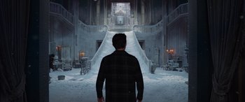 Movie still from “Spider-Man: No Way Home” (2021), directed by Jon Watts – A man standing in front of an escalator in the snow; Wide shot, Low angle