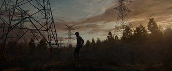 Movie still from “Spider-Man: No Way Home” (2021), directed by Jon Watts – A man standing in a field next to power lines at sunset; Extreme Wide shot, Low angle