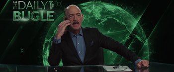 Movie still from “Spider-Man: No Way Home” (2021), directed by Jon Watts – A man sitting at a desk in front of a globe; Medium shot, High angle