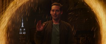 Movie still from “Spider-Man: No Way Home” (2021), directed by Jon Watts – A man in a brown jacket waving his hand; Medium shot, Over the shoulder angle