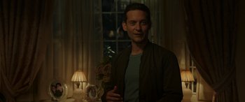 Movie still from “Spider-Man: No Way Home” (2021), directed by Jon Watts – A man standing in front of a lamp in a room; Medium shot, Over the shoulder angle