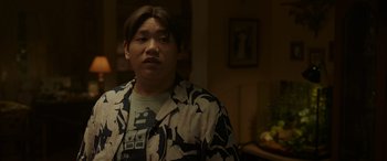 Movie still from “Spider-Man: No Way Home” (2021), directed by Jon Watts – A man in a black and white jacket is looking at the camera; Close Up shot, Over the shoulder angle