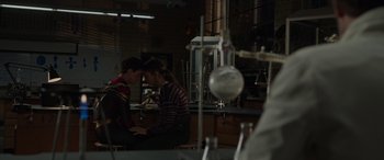 Movie still from “Spider-Man: No Way Home” (2021), directed by Jon Watts – Two people sitting at a table in front of a laptop computer; Medium shot, Over the shoulder angle
