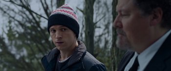 Movie still from “Spider-Man: No Way Home” (2021), directed by Jon Watts – A man wearing a hat standing next to another man in the woods; Close Up shot, Over the shoulder angle
