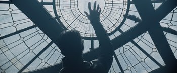 Movie still from “Spider-Man: No Way Home” (2021), directed by Jon Watts – A man reaching up into a stained - glass window; Medium shot, Low angle