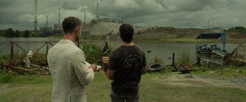 Movie still from “Spiderhead” (2022), directed by Joseph Kosinski – Two men standing in front of a body of water; Wide shot, Over the shoulder angle