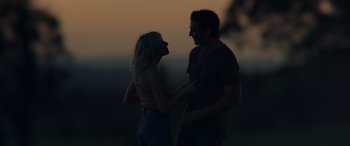 Movie still from “Spiderhead” (2022), directed by Joseph Kosinski – A man and a woman holding hands in the dark; Medium shot, Low angle