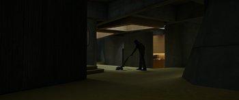 Movie still from “Spiderhead” (2022), directed by Joseph Kosinski – A man is vacuuming the floor in the dark; Extreme Wide shot, High angle