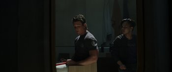 Movie still from “Spiderhead” (2022), directed by Joseph Kosinski – A man standing in front of a counter; Medium shot, Over the shoulder angle