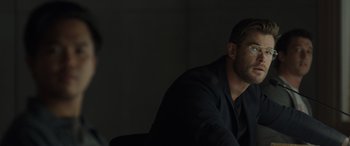 Movie still from “Spiderhead” (2022), directed by Joseph Kosinski – A man sitting in front of a wall with his eyes closed; Close Up shot, Over the shoulder angle