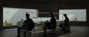 Movie still from “Spiderhead” (2022), directed by Joseph Kosinski – A group of people sitting in a room; Wide shot, Over the shoulder angle