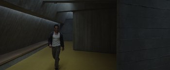 Movie still from “Spiderhead” (2022), directed by Joseph Kosinski – A man walking in an empty room in a building; Wide shot, High angle