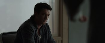 Movie still from “Spiderhead” (2022), directed by Joseph Kosinski – A person wearing a jacket; Close Up shot, Over the shoulder angle