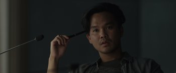 Movie still from “Spiderhead” (2022), directed by Joseph Kosinski – A man holding a knife to his head; Close Up shot, Low angle