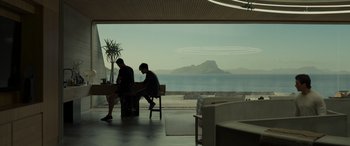 Movie still from “Spiderhead” (2022), directed by Joseph Kosinski – Two men sitting at a table in front of the ocean; Extreme Wide shot, Over the shoulder angle