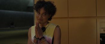 Movie still from “Spiderhead” (2022), directed by Joseph Kosinski – A woman with her hands in prayer position in front of a wall; Close Up shot, Over the shoulder angle