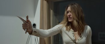 Movie still from “Spiderhead” (2022), directed by Joseph Kosinski – A woman in a white shirt is holding a video camera; Close Up shot, Low angle