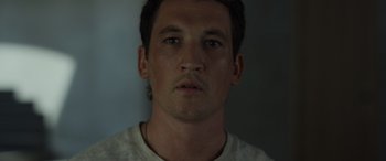 Movie still from “Spiderhead” (2022), directed by Joseph Kosinski – A person wearing a white t - shirt; Close Up shot, Low angle