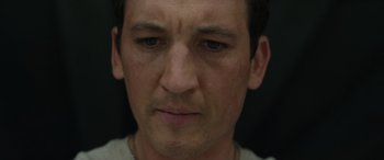 Movie still from “Spiderhead” (2022), directed by Joseph Kosinski – A man's face with a black background; Close Up shot, Low angle