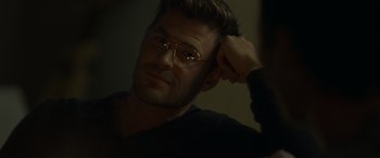 Movie still from “Spiderhead” (2022), directed by Joseph Kosinski – A person wearing glasses with one hand on his head; Close Up shot, Over the shoulder angle