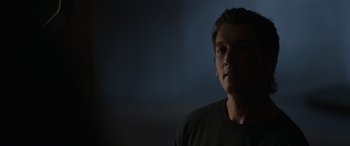 Movie still from “Spiderhead” (2022), directed by Joseph Kosinski – A person in a dark room; Close Up shot, Over the shoulder angle