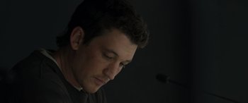 Movie still from “Spiderhead” (2022), directed by Joseph Kosinski – A person looking down at a microphone; Close Up shot, Low angle