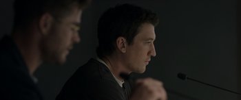 Movie still from “Spiderhead” (2022), directed by Joseph Kosinski – A person sitting in front of a wall; Close Up shot, Over the shoulder angle