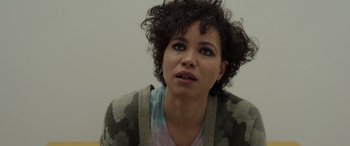 Movie still from “Spiderhead” (2022), directed by Joseph Kosinski – A person with curly black hair; Close Up shot, Over the shoulder angle