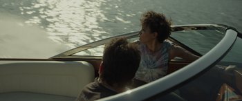Movie still from “Spiderhead” (2022), directed by Joseph Kosinski – Two young boys sitting in a boat on the water; Medium shot, Over the shoulder angle