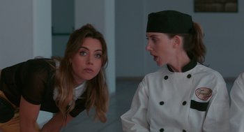 Movie still from “Spin Me Round” (2022), directed by Jeff Baena – A woman and a woman wearing a chef's outfit; Medium shot, Over the shoulder angle