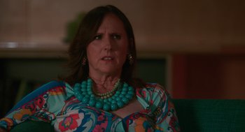 Movie still from “Spin Me Round” (2022), directed by Jeff Baena – A person wearing a necklace; Close Up shot, Over the shoulder angle