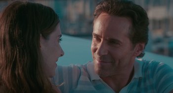 Movie still from “Spin Me Round” (2022), directed by Jeff Baena – A man and a woman sitting next to each other in a car; Close Up shot, Over the shoulder angle