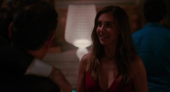 Movie still from “Spin Me Round” (2022), directed by Jeff Baena – A woman in a red dress smiling at the camera; Close Up shot, Over the shoulder angle