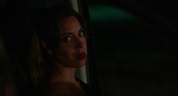 Movie still from “Spin Me Round” (2022), directed by Jeff Baena – A beautiful woman with dark hair and green eyes; Close Up shot, Over the shoulder angle