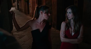 Movie still from “Spin Me Round” (2022), directed by Jeff Baena – Two women standing next to each other on a sidewalk; Medium shot, Over the shoulder angle