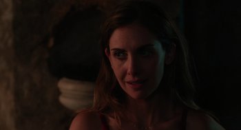 Movie still from “Spin Me Round” (2022), directed by Jeff Baena – A woman's face in the dark; Close Up shot, Over the shoulder angle