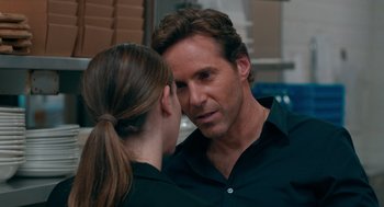 Movie still from “Spin Me Round” (2022), directed by Jeff Baena – A man and a woman looking at one another; Close Up shot, Over the shoulder angle