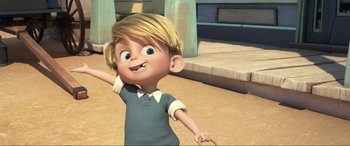 Movie still from “Spirit Untamed” (2021), directed by Ennio Torresan – A little boy with blond hair is standing in the sand; Medium shot, High angle