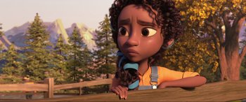 Movie still from “Spirit Untamed” (2021), directed by Ennio Torresan – A person with curly black hair is holding a cat in his arms; Close Up shot, Over the shoulder angle