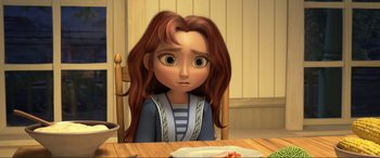 Movie still from “Spirit Untamed” (2021), directed by Ennio Torresan – A girl sitting at a table with a plate in front of her; Close Up shot, High angle