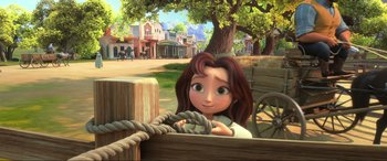 Movie still from “Spirit Untamed” (2021), directed by Ennio Torresan – A young girl sitting on a wooden bench in front of a town; Wide shot, Low angle