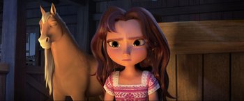 Movie still from “Spirit Untamed” (2021), directed by Ennio Torresan – A girl with long brown hair is looking at the camera; Close Up shot, Over the shoulder angle