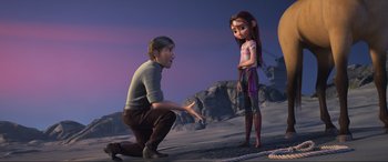 Movie still from “Spirit Untamed” (2021), directed by Ennio Torresan – A man kneeling down next to a woman in front of a mountain; Medium shot, Over the shoulder angle