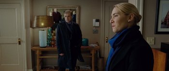 Movie still from “Carnage” (2011), directed by Roman Polanski – A man and a woman standing in front of a mirror in a room; Medium shot, Over the shoulder angle