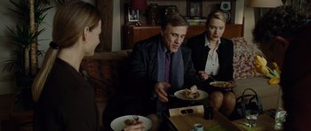 Movie still from “Carnage” (2011), directed by Roman Polanski – A group of people sitting around a table with plates of food on it; Medium shot, High angle