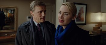 Movie still from “Carnage” (2011), directed by Roman Polanski – A man and a woman standing next to each other; Close Up shot, Over the shoulder angle