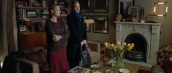 Movie still from “Carnage” (2011), directed by Roman Polanski – Two women standing at a dining room table; Medium shot, Over the shoulder angle